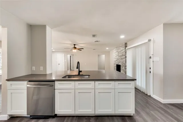 a kitchen with granite countertop a sink and a refrigerator