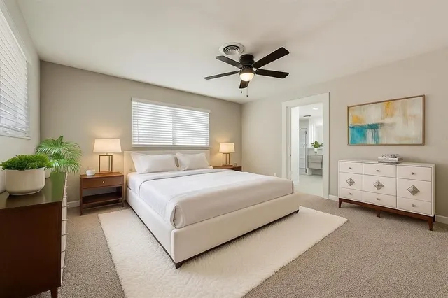 a bedroom with a bed a window and flowerpot