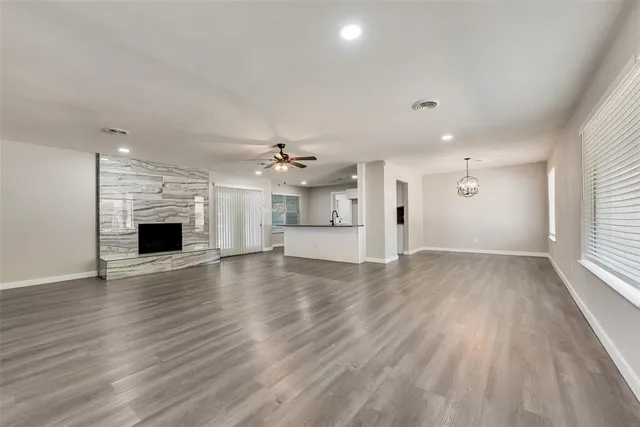 an empty room with wooden floor and fireplace
