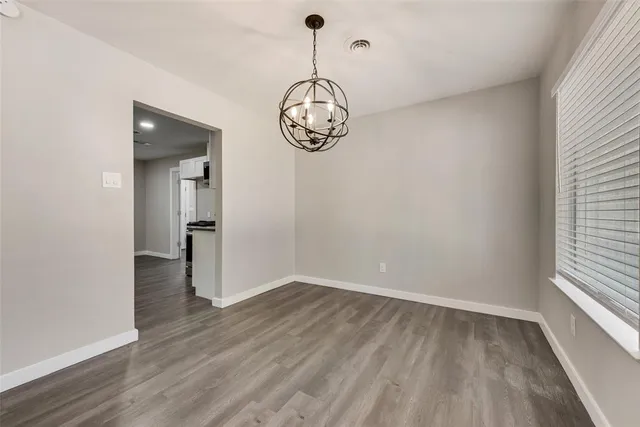 a view of a room with wooden floor fan and windows
