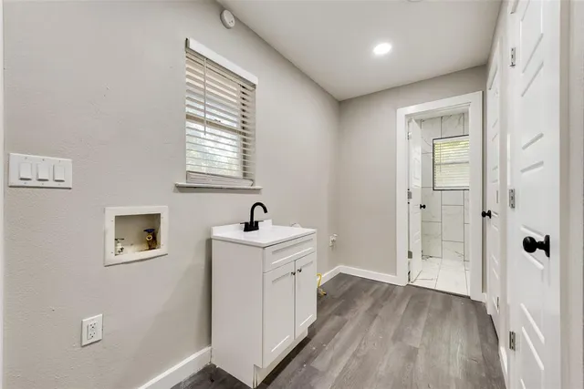 a view of a hallway with bathroom and wooden floor