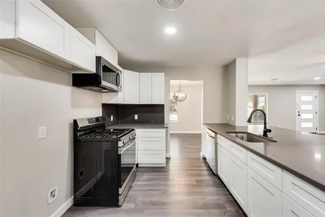 a kitchen with stainless steel appliances a sink stove and cabinets