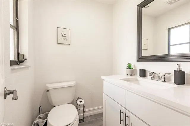 a bathroom with a sink vanity mirror and toilet