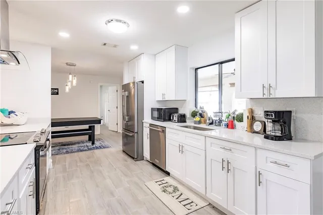 a kitchen with white cabinets and appliances