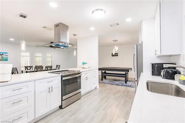a kitchen with white cabinets and appliances