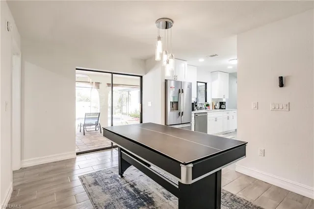 a kitchen with stainless steel appliances kitchen island granite countertop a refrigerator a stove and a sink with granite countertops