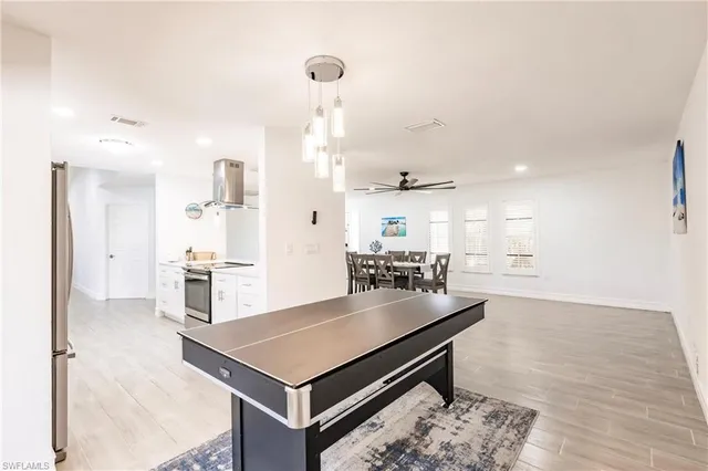 a living room with furniture a table and kitchen view