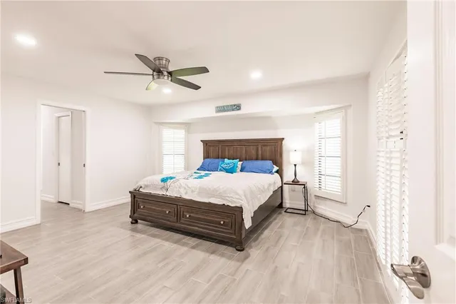 a bed sitting in a spacious bedroom next to a window