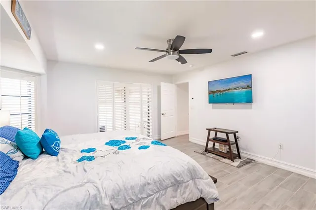 a bedroom with a bed a couch and a flat screen tv