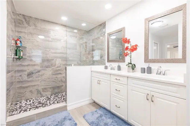 a bathroom with a double vanity sink mirror and shower