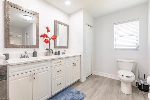 a bathroom with a granite countertop toilet sink and mirror