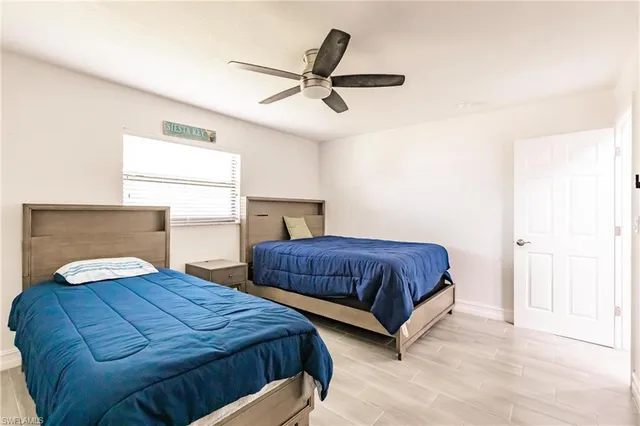 a bedroom with two beds and painting on the wall