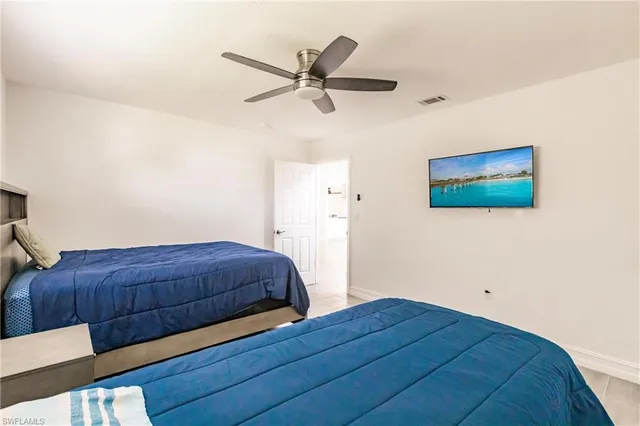 a bed room with a bed and a ceiling fan