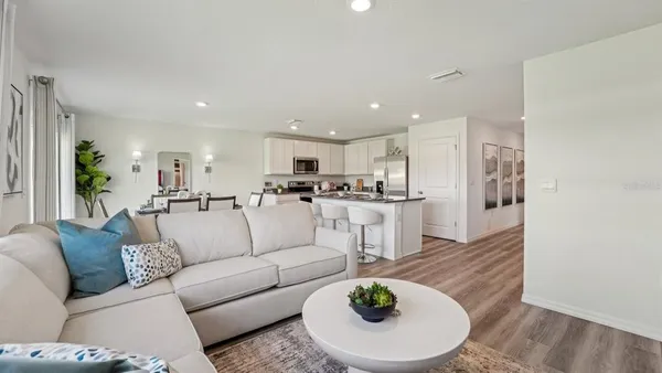 a living room with furniture and kitchen view