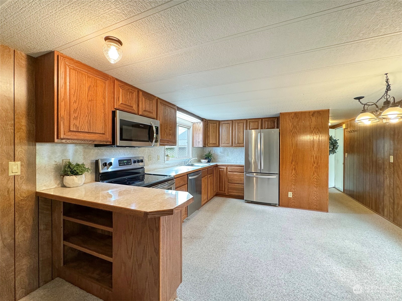 241 Evans Road Sequim, WA 98382 - Photo 10 of 40 a kitchen with stainless steel appliances granite countertop a stove a sink and a refrigerator