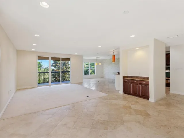 an empty room with a kitchen and a window