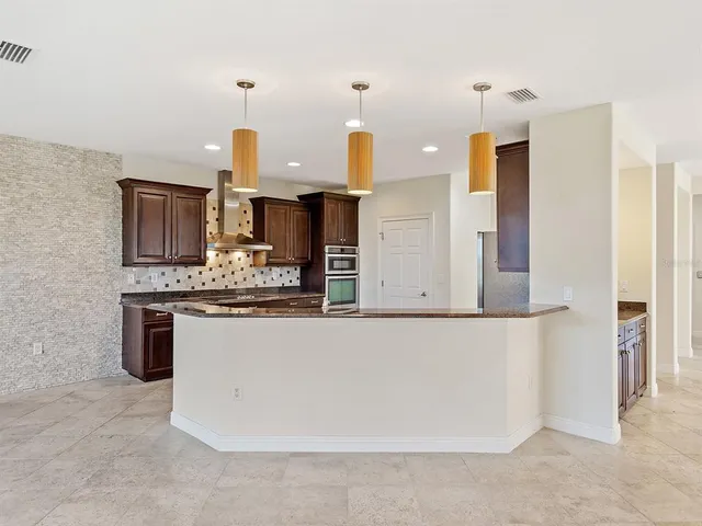 a large kitchen with kitchen island granite countertop a sink and a refrigerator