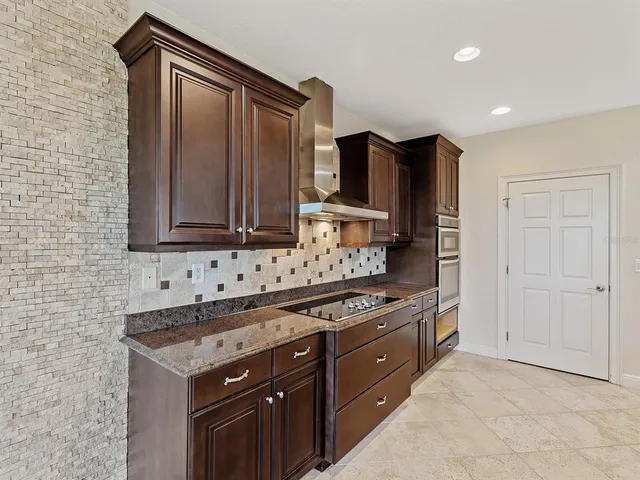 a kitchen with stainless steel appliances granite countertop a stove a sink and a microwave
