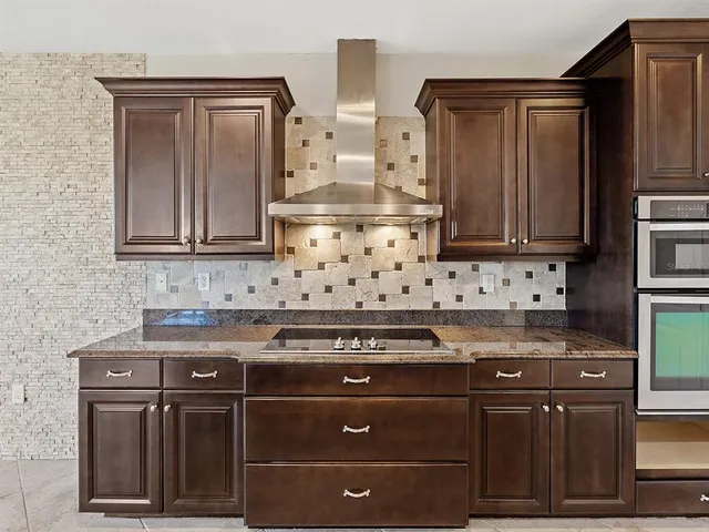 a kitchen with stainless steel appliances wooden cabinets and a stove top oven
