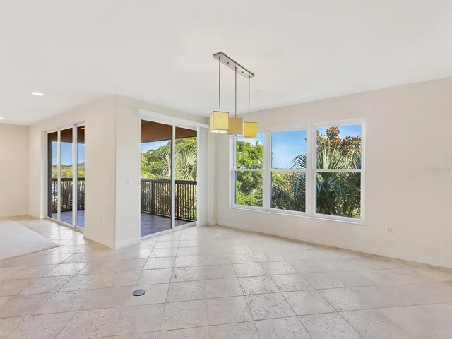 a view of an empty room with windows & cabinet