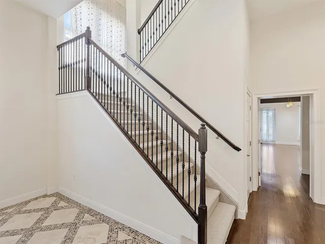 a view of staircase with wooden floor and white walls