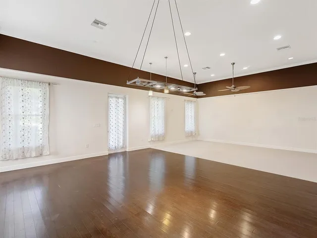 a view of an empty room with wooden floor