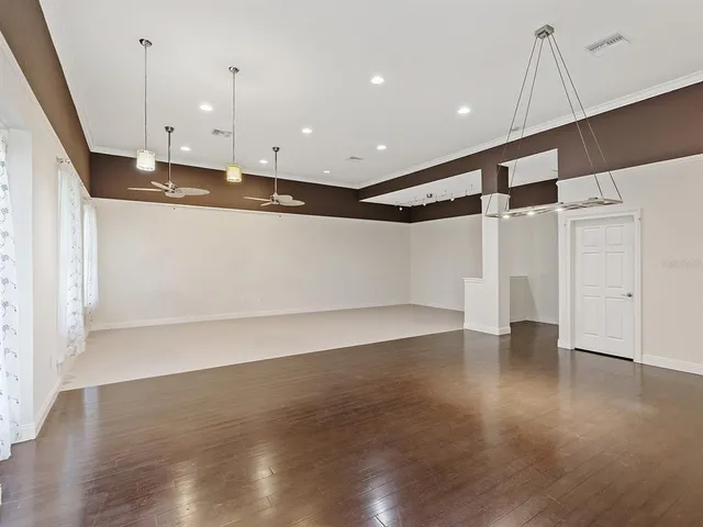 a view of an empty room with wooden floor