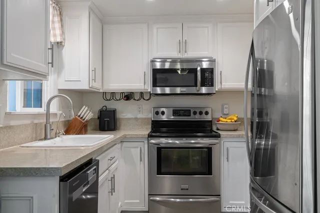 a kitchen with stainless steel appliances a stove a sink and a microwave