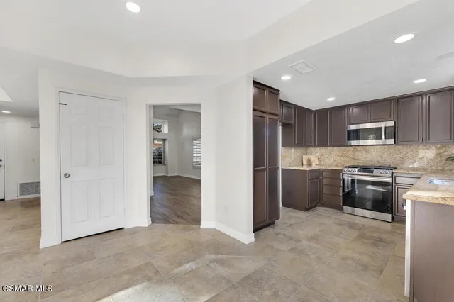 a view of kitchen with refrigerator stove microwave and cabinets