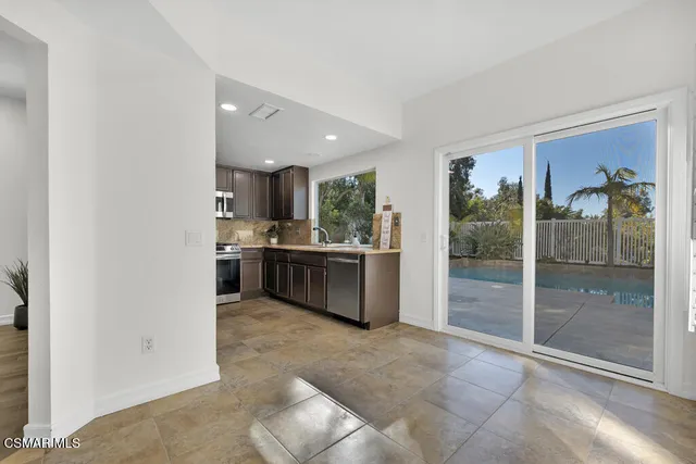 a open kitchen with a sink and refrigerator