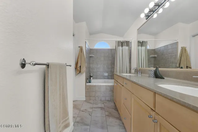 a spacious bathroom with a granite countertop sink a toilet a mirror and shower