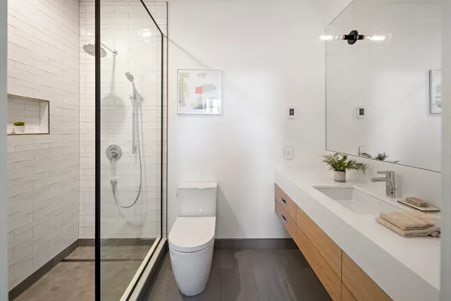 a bathroom with a sink a toilet and shower