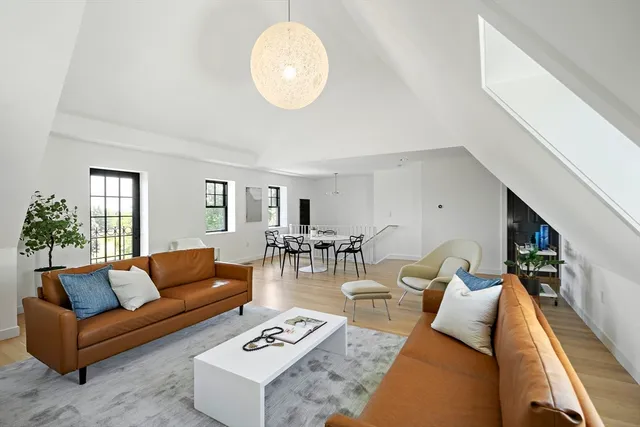 a living room with furniture wooden floor and a large window
