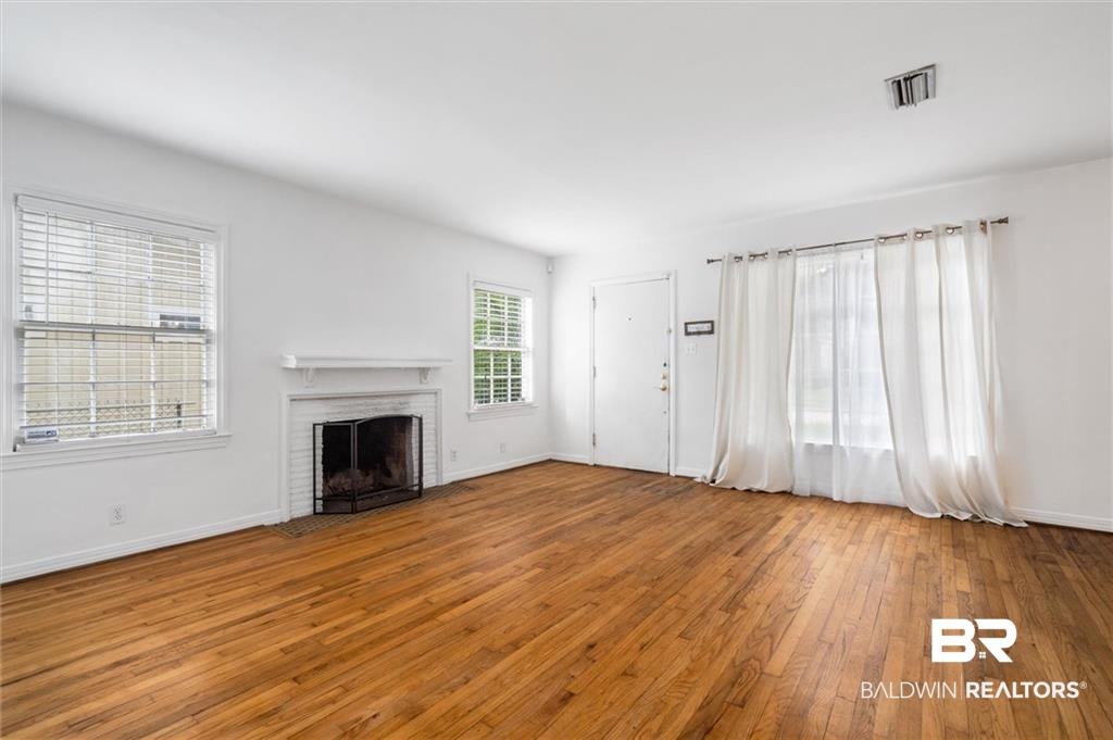 218 Grand Boulevard Mobile, AL 36607 - Photo 21 of 22 Unfurnished living room featuring a fireplace and hardwood / wood-style flooring