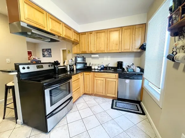 a kitchen with granite countertop a sink stove top oven and cabinets
