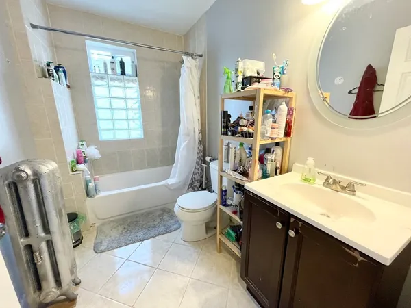 a bathroom with a sink vanity mirror bathtub and toilet