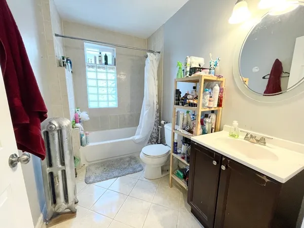 a bathroom with a sink vanity mirror bathtub and toilet