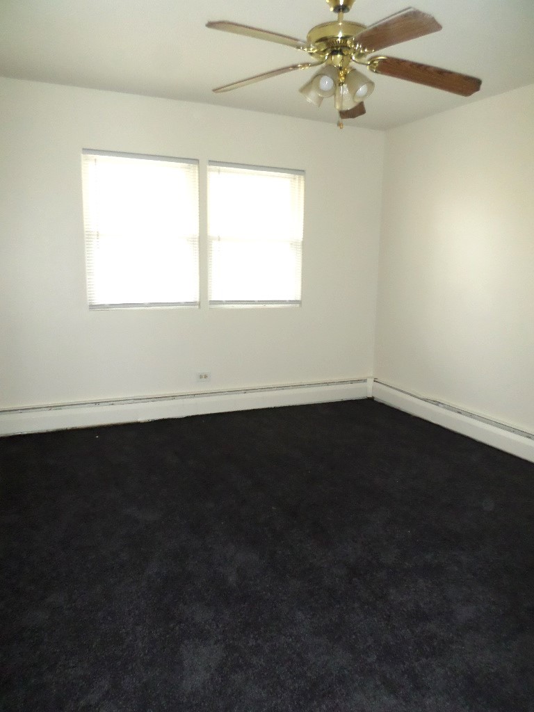 3546 147th Street, Unit 8 Midlothian, IL 60445 - Photo 6 of 8 a view of an empty room with wooden floor and a window