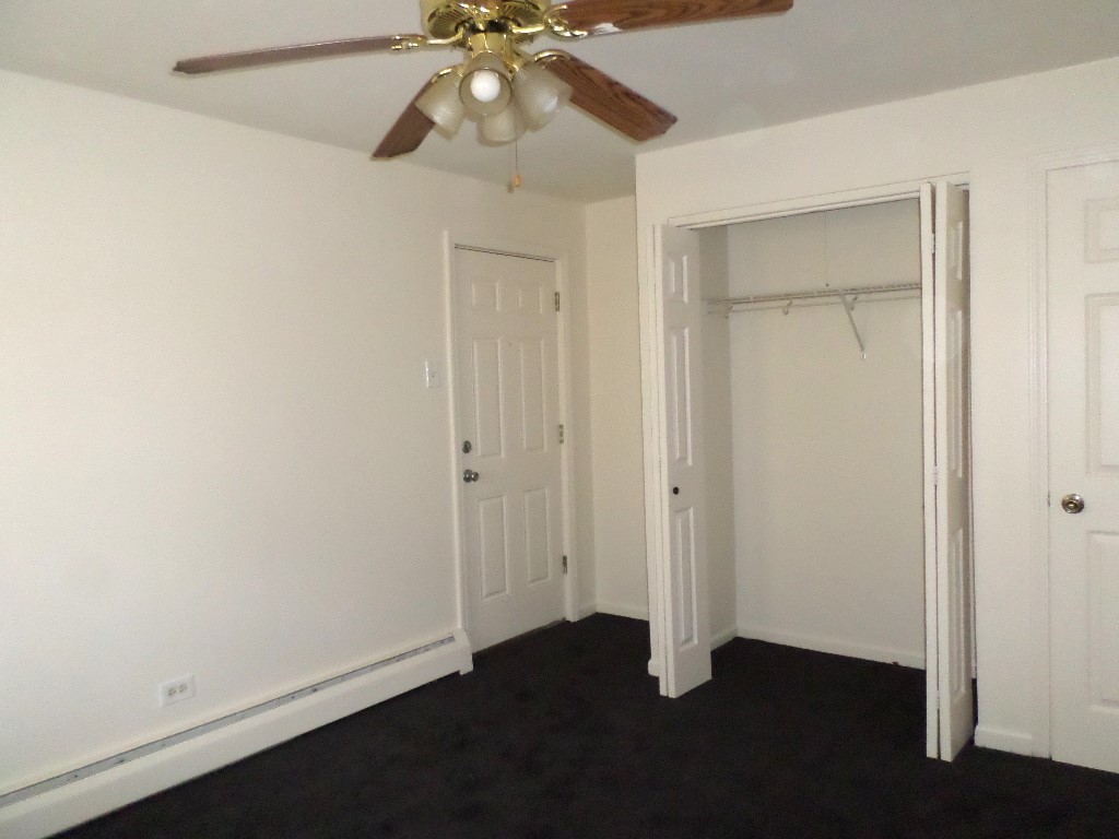3546 147th Street, Unit 8 Midlothian, IL 60445 - Photo 7 of 8 an empty room with a ceiling fan and wooden floor