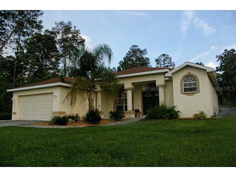 10046 Elgin Boulevard Spring Hill, FL 34608 - Photo 1 of 1 a front view of a house with a garden and plants