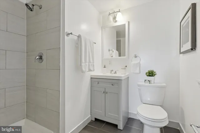 a bathroom with a toilet sink vanity and mirror
