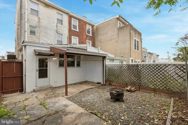 a backyard of a house with glass top table and chairs