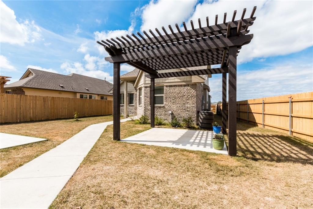 2104 Pindos Pony Way Georgetown, TX 78626 - Photo 26 of 30 A spacious backyard with a custom pergola and a privacy fence.