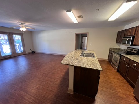 203 Kelly Road, Unit 114 Clemson, SC 29631 - Photo 8 of 37 Rich wood floors seamlessly connect the central kitchen island to the living area.