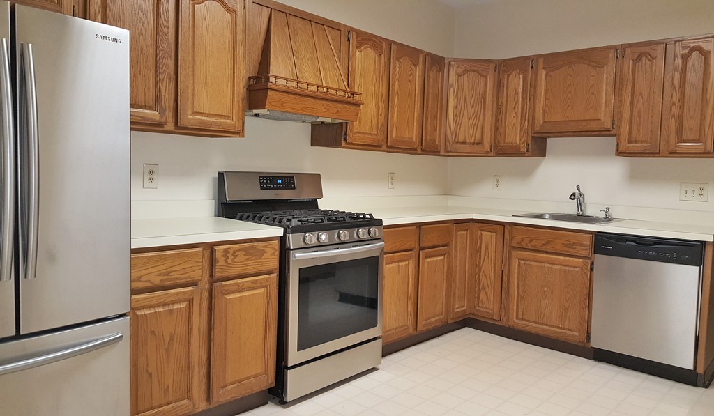 a kitchen with granite countertop cabinets stainless steel appliances and sink