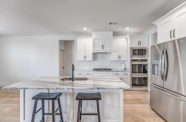 a kitchen with kitchen island a sink stove and refrigerator