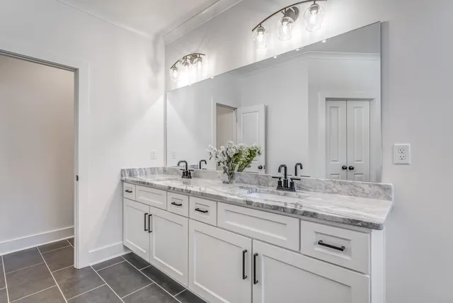a bathroom with a double vanity sink a mirror and a bathtub