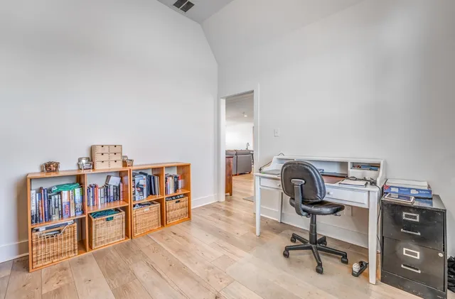 a bedroom with a bed chair and two windows