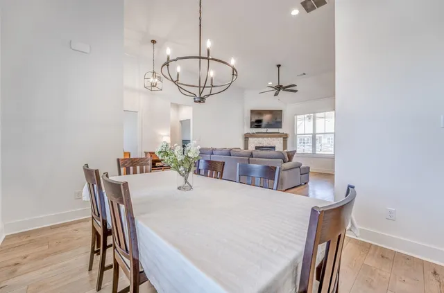a view of a dining room with furniture a chandelier and wooden floor