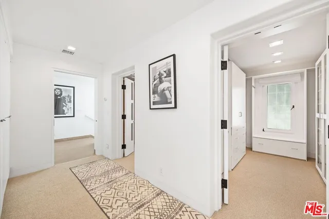 a view of a hallway with closet and bathroom